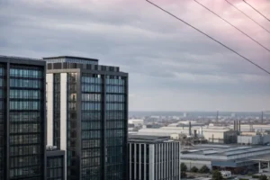 Gratte-ciel modernes reflétés au crépuscule, horizon industriel et lignes électriques survolant le paysage urbain. marche travail roumanie inclue naturellement? Non, just description. Alt: Gratte-ciel modernes près d’un bassin urbain industriel au crépuscule.